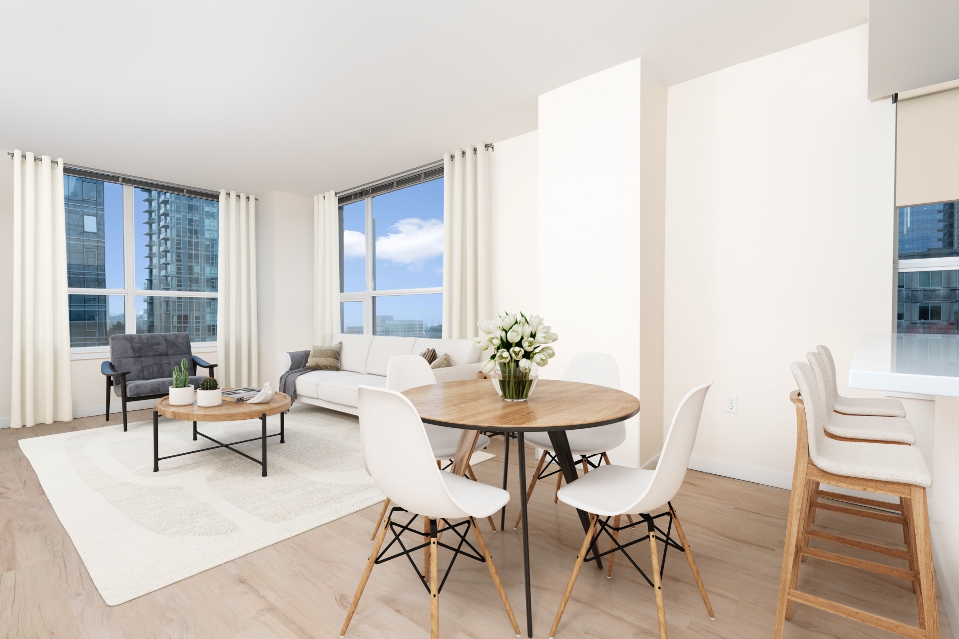 A modern dining room with a round table and white chairs.